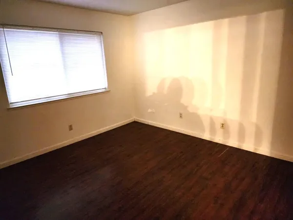 a view of a small space with wooden floor and a window