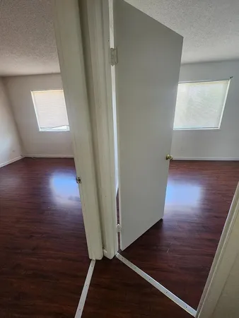 a view of a hallway with wooden floor and staircase
