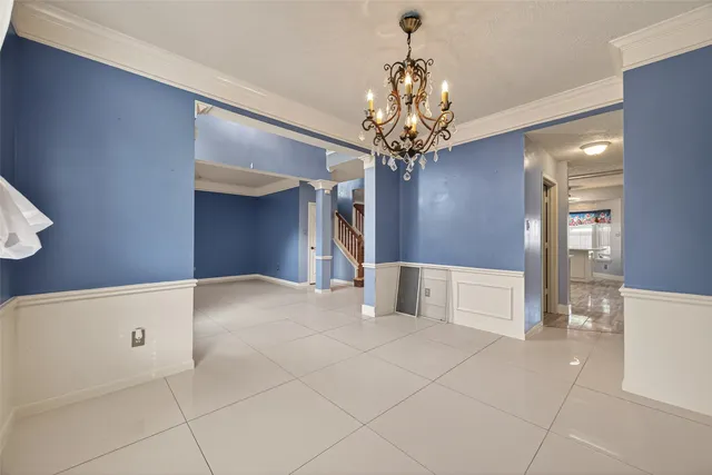 a view of a livingroom with a chandelier furniture and kitchen view