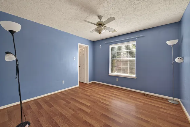 a view of an empty room with a ceiling fan and a window
