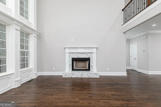 a view of an empty room with wooden floor a fireplace