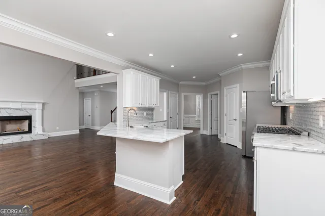 a large kitchen with stainless steel appliances granite countertop a stove and a sink