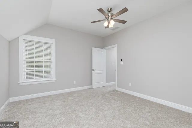 an empty room with closet and windows