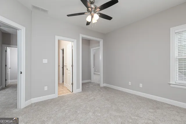 an empty room with a window and a fan