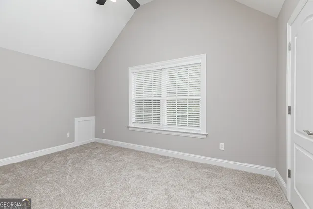 an empty room with ceiling fan and window