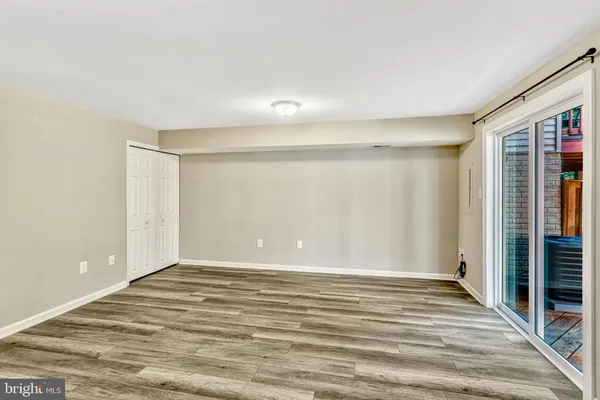 a view of an empty room with wooden floor and closet