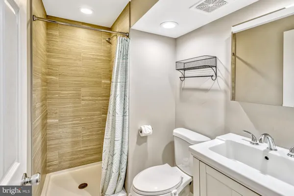 a bathroom with a shower a sink and toilet