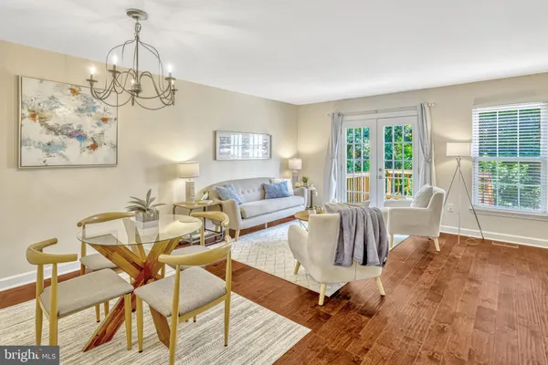 a view of a dining room with furniture a chandelier and wooden floor