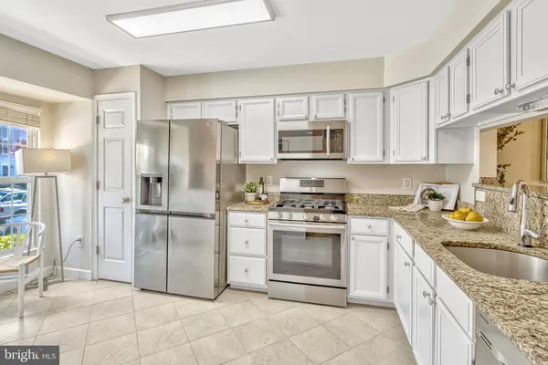 a kitchen with stainless steel appliances granite countertop a refrigerator stove and sink