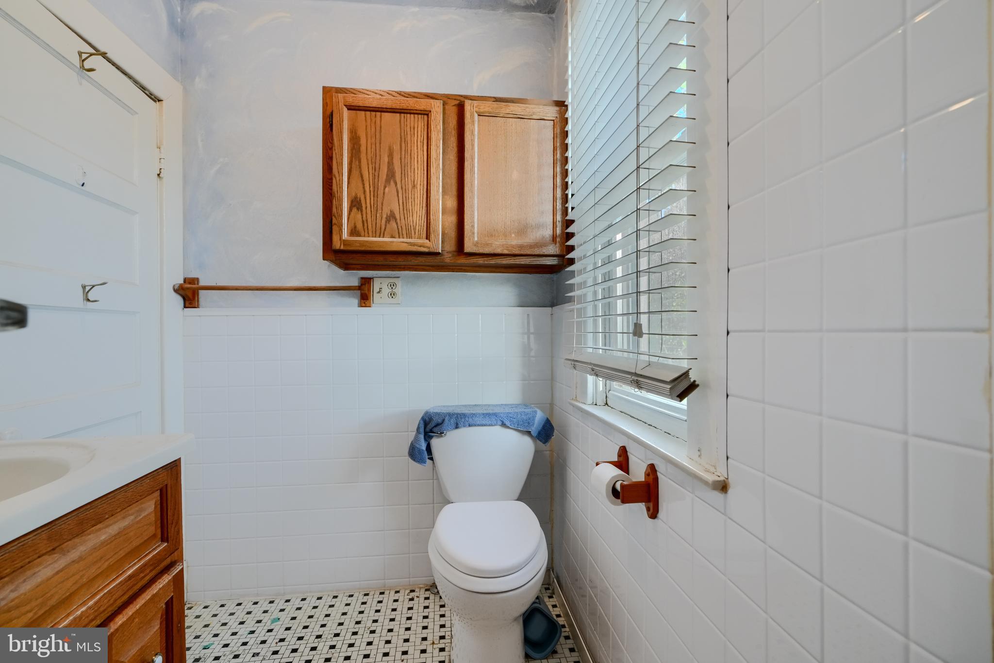5312 Catalpha Road Baltimore, MD 21214 - Photo 29 of 37 a bathroom with a toilet and a shower curtain