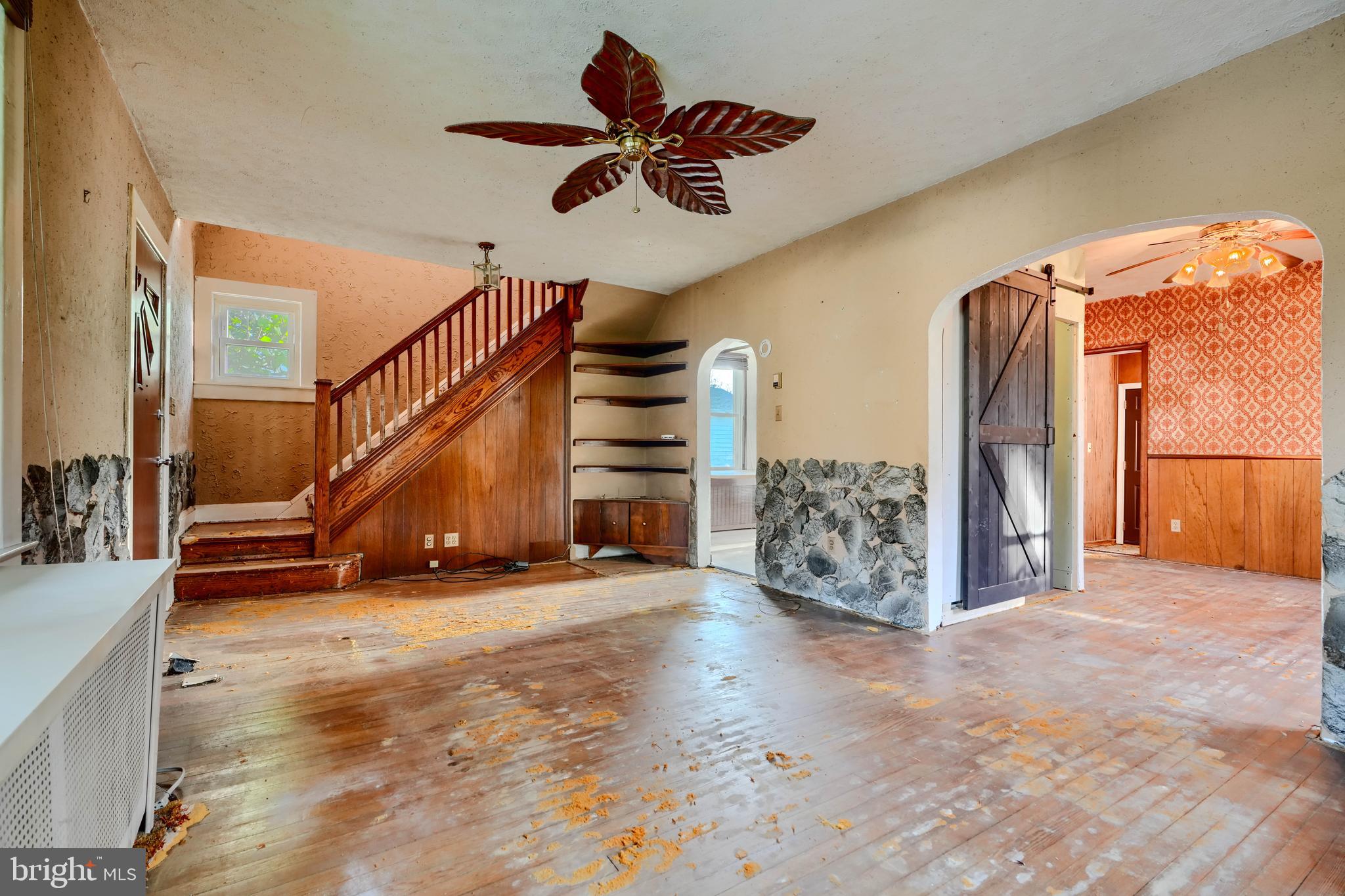 5312 Catalpha Road Baltimore, MD 21214 - Photo 6 of 37 a view of an empty room with stairs and a ceiling fan