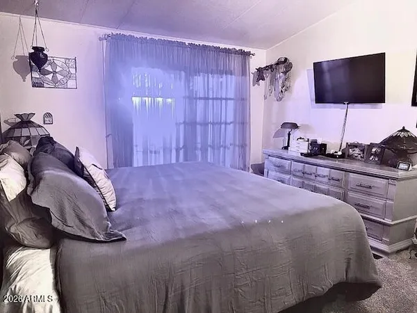 a bedroom with a bed and a flat screen tv