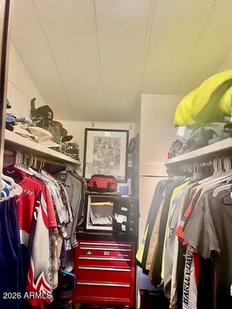 a view of walk in closet with clothes and shoes