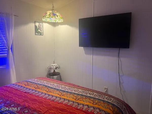 a bedroom with a bed and a flat screen tv