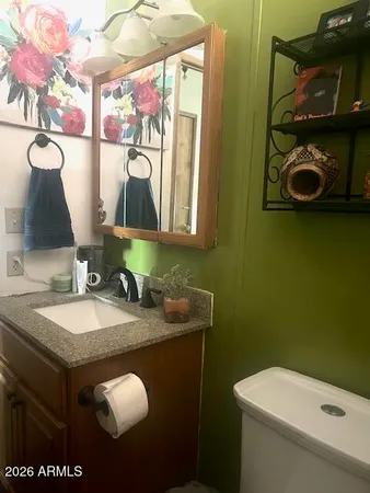 a bathroom with a granite countertop sink a toilet and mirror