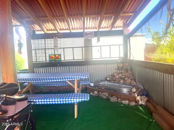 a view of a chair and table in backyard of the house
