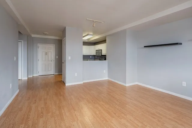 a view of a kitchen with wooden floor and a window