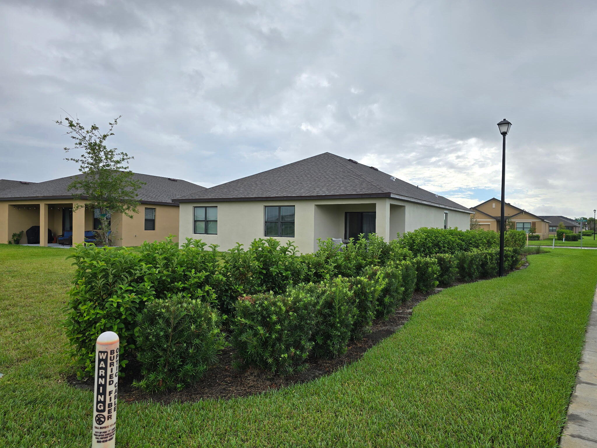 9725 Southwest Triton Way Port Port St. Lucie, FL 34987 - Photo 11 of 12 a front view of a house with a yard