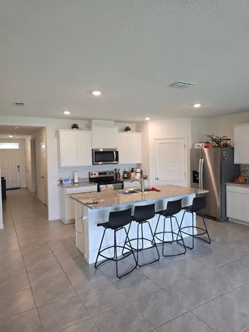 a kitchen with stainless steel appliances kitchen island granite countertop a sink and cabinets