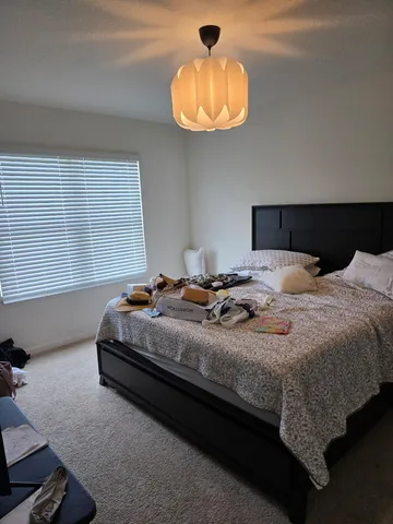 a bedroom with bed and a chandelier