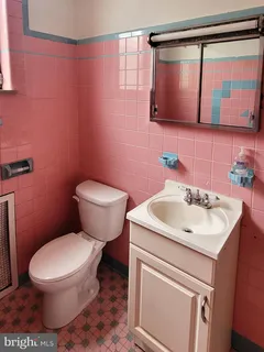 a bathroom with a toilet sink and mirror