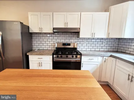 a kitchen with a stove a sink and a refrigerator