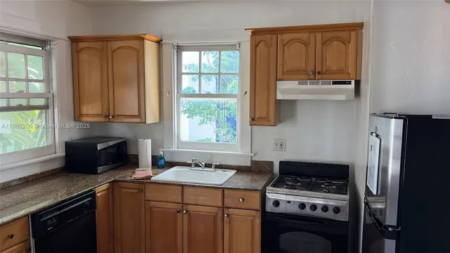 a kitchen with a stove a sink and a refrigerator