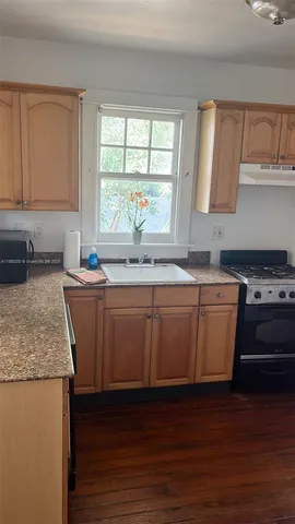 a kitchen with granite countertop a sink and a stove