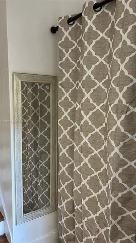 a view of a small space with wooden floor and a fan