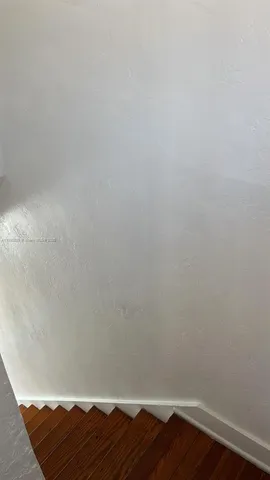 a view of a room with wooden floor and white walls