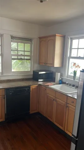 a kitchen with a sink wooden floor and a window