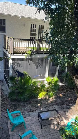 a backyard of a house with a garden and outdoor seating