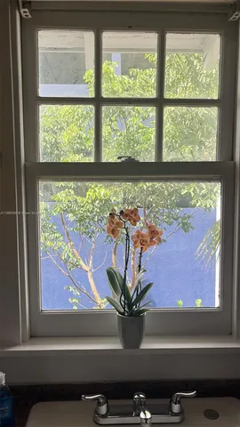a vase of flowers sitting on a window sill and a room