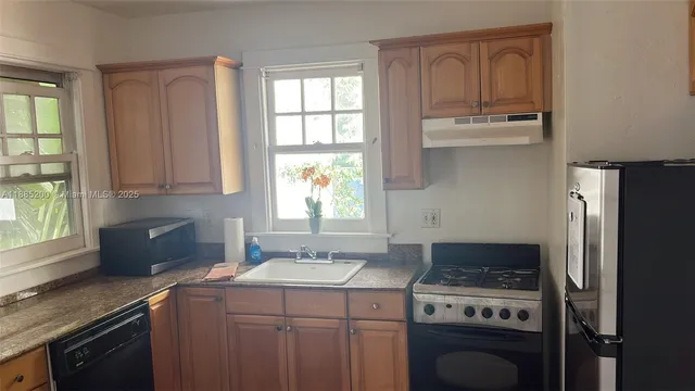 a kitchen with a stove a sink and a refrigerator