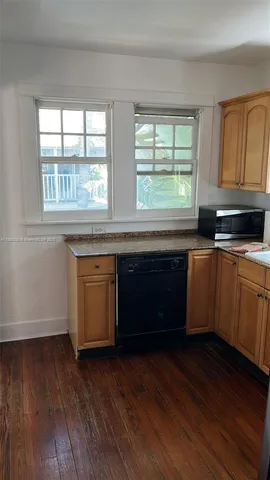 a kitchen with stainless steel appliances granite countertop wooden floors and sink