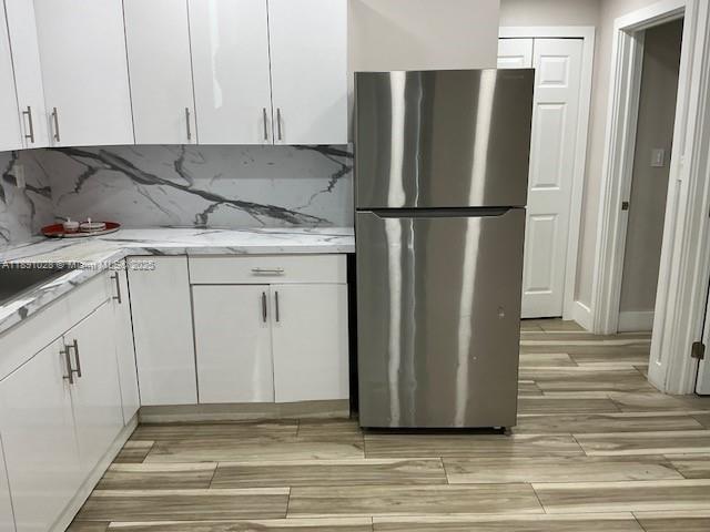 922 Northwest 2nd Street, Unit 1 Miami, FL 33128 - Photo 21 of 26 a view of a refrigerator in kitchen and white cabinets