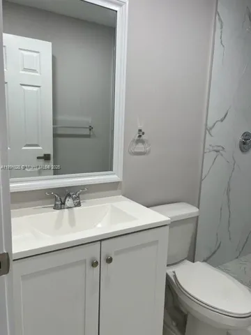 a white toilet sitting next to a bath tub