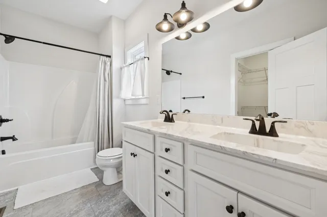 a bathroom with a granite countertop sink a toilet and a bathtub