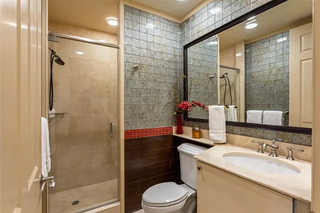 a bathroom with a granite countertop sink toilet and shower