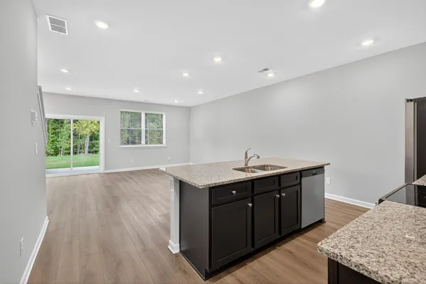 a kitchen with a sink a window and wooden floor