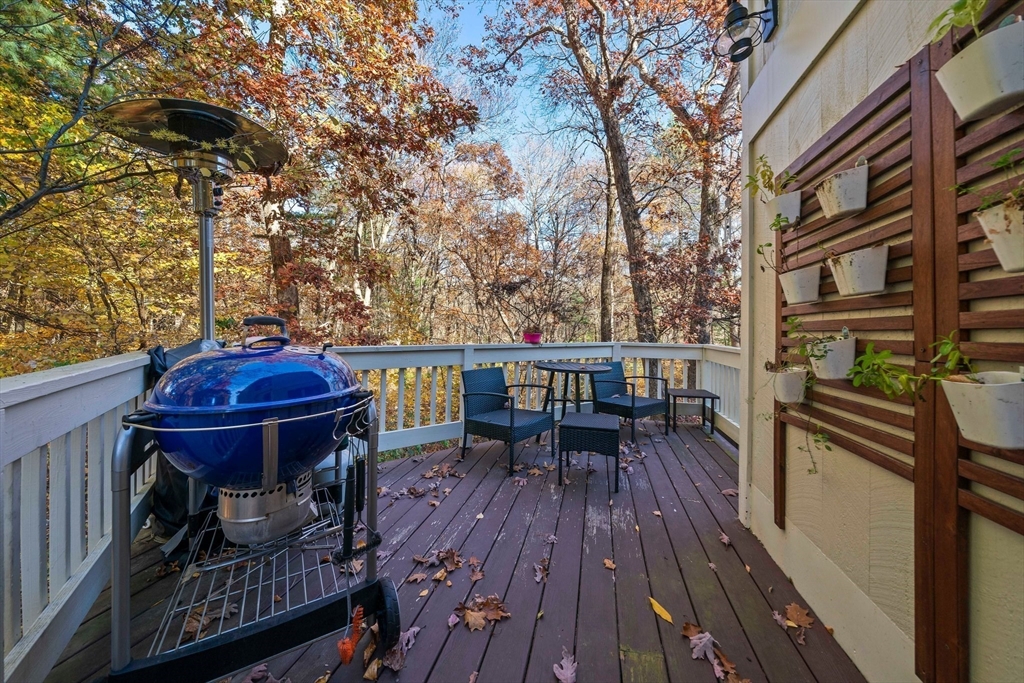 24 Pammys Path Easton, MA 02356 - Photo 5 of 39 a view of a roof deck with table and chairs couches with wooden floor and fence