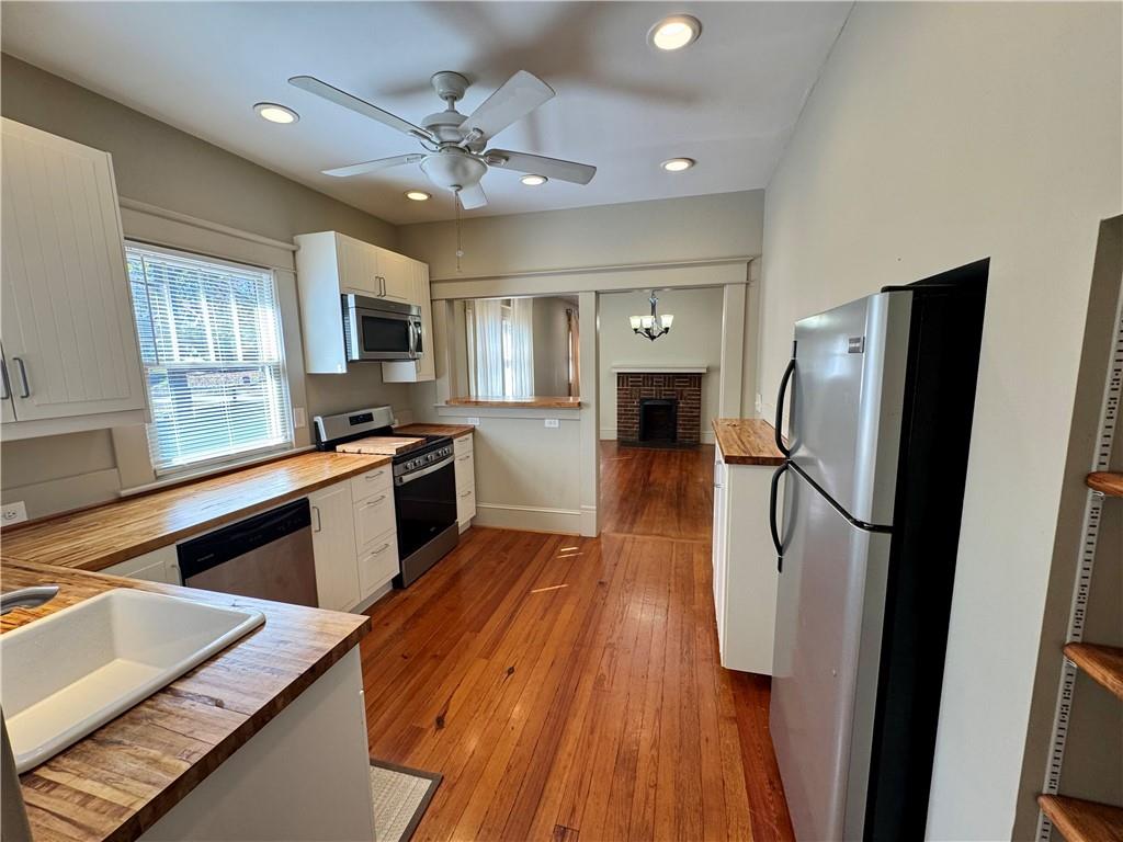 2482 Maple Street East Point, GA 30344 - Photo 14 of 39 a kitchen with stainless steel appliances a refrigerator a stove a sink dishwasher and a stove with wooden floor