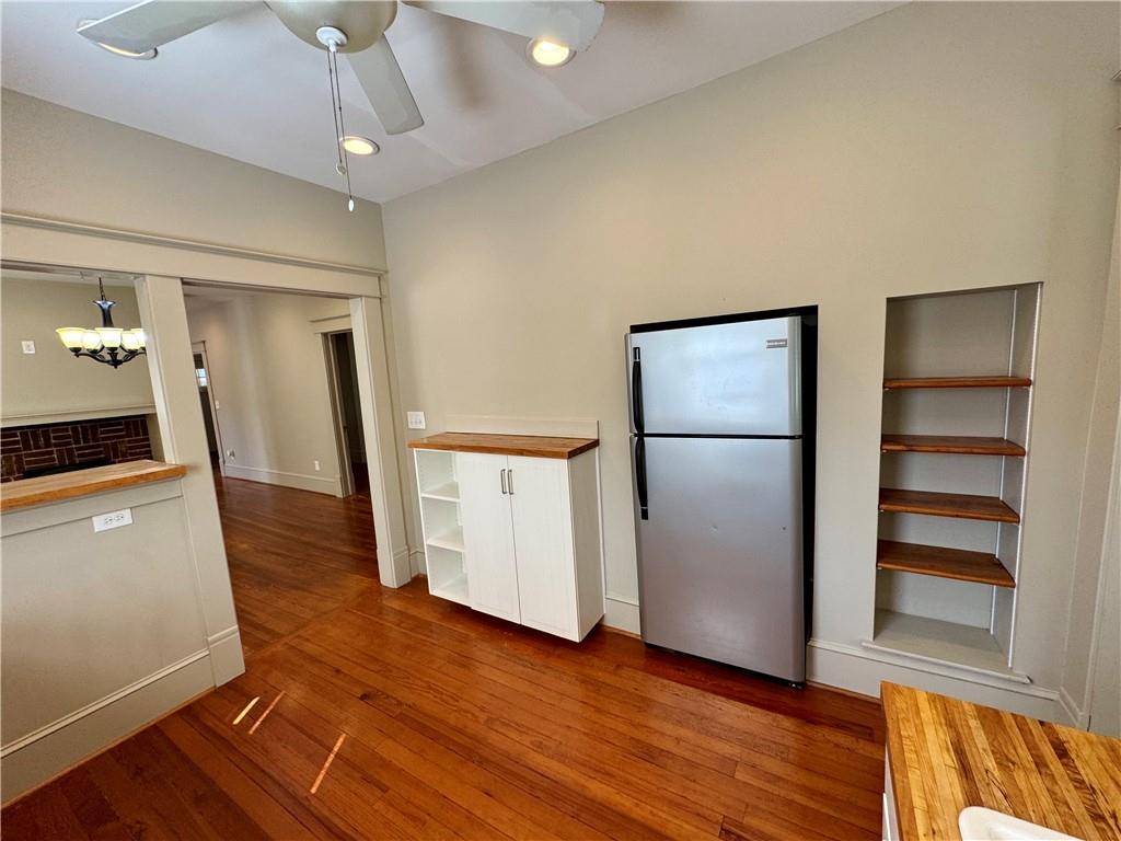 2482 Maple Street East Point, GA 30344 - Photo 16 of 39 a view of a refrigerator in kitchen and an empty room with wooden floor