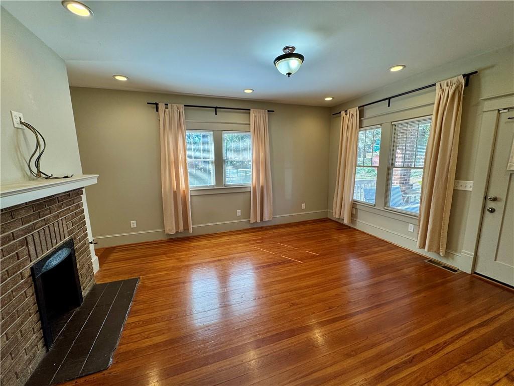 2482 Maple Street East Point, GA 30344 - Photo 4 of 39 an empty room with wooden floor and fireplace
