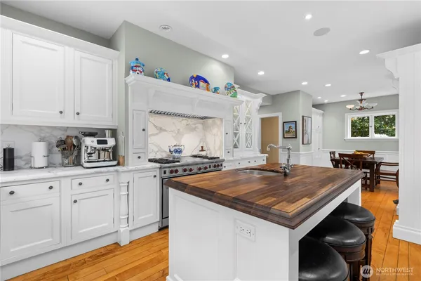 a kitchen with granite countertop a stove and white cabinets