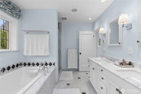 a bathroom with a tub sink and mirror