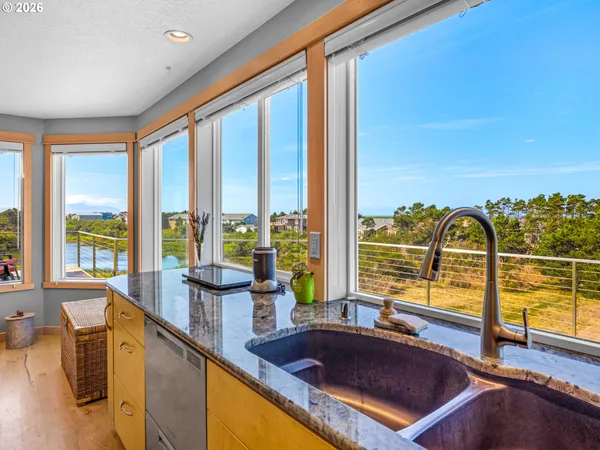 a kitchen with sink and view of living room