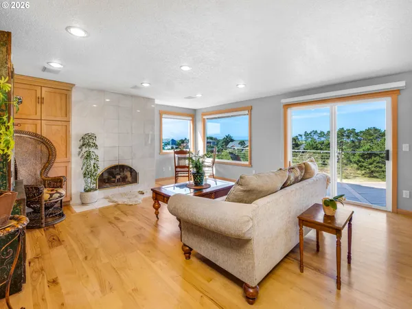 a living room with furniture a large window and a wooden floor
