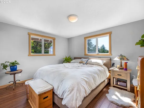a bedroom with a bed and a table in it next to a window