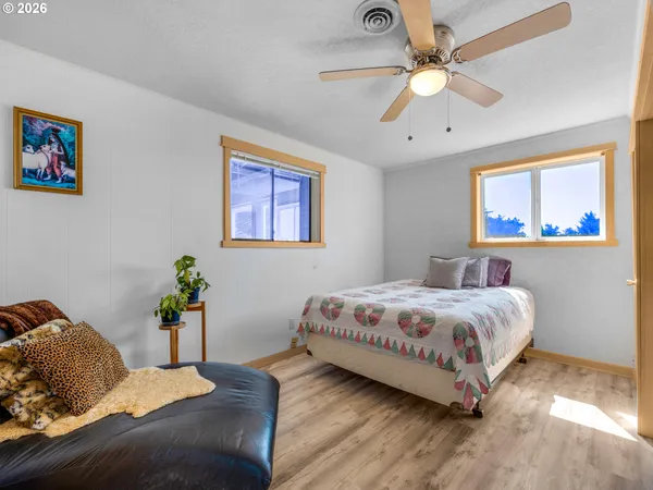 a bedroom with a bed ceiling fan and a window
